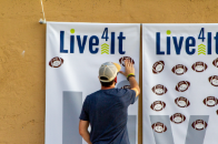 man posting football sticky note on board at a live4it event